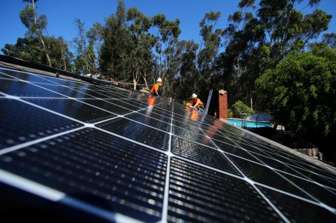 Công nhân lắp điện mặt trời trên mái nhà tại California (Mỹ)